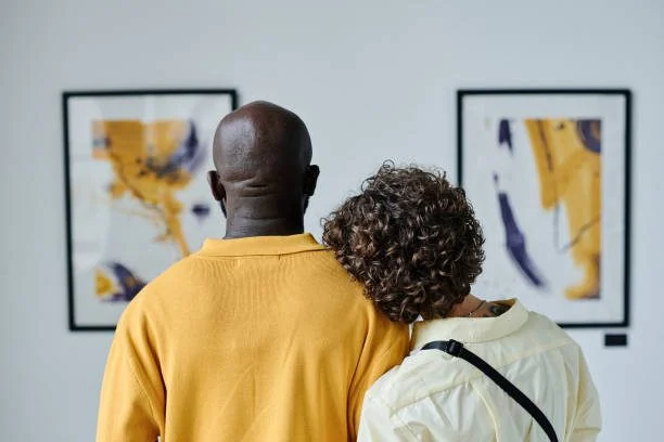 A couple viewing paintings in a gallery